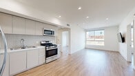 Located at 5639 Lexington Ave in the heart of Los Angeles, CA, this modern 2-bedroom, 2-bathroom unit offers a thoughtfully designed open-concept layout with clean lines and a bright, contemporary aesthetic. Light wood-style flooring flows seamlessly throughout the entire space, complementing the crisp white walls and recessed lighting that keep the interior feeling airy and well-lit.

The combined kitchen and living area serves as the heart of the unit. The kitchen is outfitted with sleek flat-panel cabinetry, a subway tile backsplash, and a full suite of stainless steel appliances including a gas range, over-the-range microwave, dishwasher, and French door refrigerator. The open layout connects directly to the living area, which benefits from large windows that invite natural light and offer views of the surrounding neighborhood.

Both bedrooms are generously proportioned, with the spacious primary bedroom featuring a large window with outdoor views and ample room for furnishings. The second bedroom also benefits from natural light via a corner window. A dedicated closet provides convenient storage.

The two bathrooms are finished with modern tilework, including hexagonal floor tiles and large-format wall tiles in the shower/tub surrounds. Sliding glass shower doors and clean-lined vanities complete the polished look throughout.