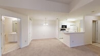 Located at 410 Jason Dr B11 in Richmond, Kentucky, this single-floor unit offers a clean, functional layout designed for comfortable everyday living. The open-concept living and dining area is highlighted by vaulted ceilings with a ceiling fan, soft neutral-toned carpet, and an elegant chandelier that anchors the dining space. Natural light filters in through a set of double doors leading to an outdoor area, creating a bright and welcoming atmosphere throughout.

The galley-style kitchen is efficiently designed with white cabinetry, a white tile floor, and a full suite of appliances including a range, microwave, and refrigerator. A breakfast bar provides a seamless connection between the kitchen and the living area, making it ideal for casual dining or entertaining.

The unit includes two well-proportioned bedrooms, each featuring plush carpet and windows with blinds that allow for ample natural light and exterior views. The bathroom is thoughtfully laid out with a wide vanity featuring white cabinetry, a large mirror, tile flooring, and a private water closet housing a full tub and shower combination. Additional storage is available via a closet with built-in shelving. The overall palette of soft whites and neutral tones lends the space a clean, move-in-ready aesthetic.