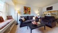 Located at 3402 Prince Robert Ct in Richmond, Virginia, this single-floor residence offers a thoughtfully laid-out living space designed for everyday comfort. The living room serves as the heart of the home, featuring plush carpeted flooring, a textured ceiling, and a built-in breakfast bar that provides a seamless connection to the kitchen. The space is well-lit and accented with a wall sconce, creating a warm and inviting atmosphere.

The kitchen is a functional galley-style space distinguished by its eye-catching black-and-white checkered tile flooring. Warm honey-toned wood cabinetry lines the walls, complemented by white countertops, a double sink, and white appliances including a refrigerator and range. A louvered pantry door adds classic character to the space.

The bedroom is generously sized, featuring soft, wall-to-wall carpeting and neutral walls that create a calm retreat. A window with blinds allows for natural light, while a louvered bi-fold closet door provides ample storage. The room comfortably accommodates a full bedroom suite.

The bathroom is clean and well-appointed, featuring tile flooring, a wood-toned vanity with a wide countertop, a large mirror, and a shower-tub combination. The neutral color palette throughout the space creates a cohesive and comfortable living environment.