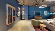 Located at 1201 W Grove St in Boise, Idaho, this single-floor community amenity space offers a generously sized, open-plan layout designed for social gatherings and recreation. The industrial-chic aesthetic is defined by exposed ceiling ductwork and conduit, polished concrete floors, and a striking exposed brick accent wall adorned with an illuminated cityscape mural — creating a bold, urban atmosphere throughout.

The space is divided into distinct functional zones that flow seamlessly into one another. A lounge area features plush sectional and curved sofas, a large-screen TV mounted on a deep blue accent wall, and warm pendant and circular LED lighting fixtures. A dedicated game zone includes a foosball table, a billiards table, and additional tabletop gaming options. The kitchen and dining area is equipped with full appliances, subway tile backsplash, a large communal bar-height table with blue upholstered seating, and marquee-letter signage that adds a playful, vibrant touch.

Large black-framed windows along one wall flood the space with natural light and offer direct views of an outdoor pool area, while a glass door provides convenient outdoor access. Track lighting and statement pendant fixtures ensure the space is well-lit throughout. The combination of curated furnishings, expressive décor, and versatile layout makes this an engaging and functional communal destination.