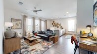 This single-story residence is designed with a cohesive contemporary aesthetic, blending clean architectural lines with warm, eclectic accents. The open-concept living area serves as the heart of the home, anchored by wood-look flooring, recessed lighting, and a ceiling fan overhead. Large windows dressed with patterned curtains and blinds fill the space with natural light, while a mix of leather seating, a bold area rug, and artful wall décor create an inviting atmosphere.

Adjacent to the living area, the galley-style kitchen is outfitted with light wood cabinetry, granite-look countertops, stainless steel appliances, and pendant lighting. Ample counter space and storage make it both functional and visually appealing. A dedicated dining area nearby features hardwood-style flooring, generous window coverage, and decorative woven wall art, lending a casual yet polished feel.

The bedroom offers a tranquil retreat with plush carpeting, natural light from sizable windows, and ample space for furnishings. Both bathrooms mirror the home's modern sensibility, featuring light wood vanities, granite countertops, undermount sinks, tub-shower combinations with tiled surrounds, and wood-look flooring throughout.