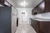 Located at 183 Michelle Cir in South Plainfield, NJ, this single-floor residence offers a thoughtfully laid-out interior designed for everyday comfort and functionality. The kitchen serves as a practical centerpiece, outfitted with rich dark-wood cabinetry, light gray countertops, a subway tile backsplash, and a full suite of stainless steel appliances including a gas range, microwave, dishwasher, and refrigerator. Light wood-look tile flooring runs throughout the kitchen, adding a clean, contemporary feel. A dedicated laundry area is conveniently accessible directly from the kitchen. The living area is generously proportioned, featuring neutral carpet, soft wall tones, and a sliding glass door that allows natural light to flow through. Multiple bedrooms continue the carpeted, neutral aesthetic, with several rooms benefiting from windows that bring in outdoor views and daylight. The bathrooms are cleanly finished — one features a full tub and shower combination with white subway tile surround, while another includes a dark-vanity with a white countertop and wall mirror. Throughout the home, the consistent use of neutral tones and quality finishes creates a cohesive, move-in-ready atmosphere.