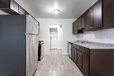 Located at 183 Michelle Cir in South Plainfield, NJ, this single-floor residence offers a thoughtfully laid-out interior designed for everyday comfort and functionality. The kitchen serves as a practical centerpiece, outfitted with rich dark-wood cabinetry, light gray countertops, a subway tile backsplash, and a full suite of stainless steel appliances including a gas range, microwave, dishwasher, and refrigerator. Light wood-look tile flooring runs throughout the kitchen, adding a clean, contemporary feel. A dedicated laundry area is conveniently accessible directly from the kitchen. The living area is generously proportioned, featuring neutral carpet, soft wall tones, and a sliding glass door that allows natural light to flow through. Multiple bedrooms continue the carpeted, neutral aesthetic, with several rooms benefiting from windows that bring in outdoor views and daylight. The bathrooms are cleanly finished — one features a full tub and shower combination with white subway tile surround, while another includes a dark-vanity with a white countertop and wall mirror. Throughout the home, the consistent use of neutral tones and quality finishes creates a cohesive, move-in-ready atmosphere.