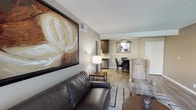 Located at 9931 Lurline Ave in the Chatsworth neighborhood of Los Angeles, this single-floor residence offers a thoughtfully designed layout with cohesive, contemporary interiors throughout. Warm neutral tones, light wood-style flooring, and textured ceilings establish a consistent aesthetic across all rooms.

The living area serves as the heart of the home, featuring a leather sofa, a bold large-scale framed artwork, and an accent chair with a distinctive zebra print. A slim media console with a flat-screen TV anchors one wall, while a plush area rug and round coffee table complete the arrangement. The space flows naturally into the dining area, which is outfitted with a dark wood table, black upholstered chairs, a decorative mirror, and a ceiling fan overhead.

The kitchen features dark cabinetry and connects seamlessly to the dining space. The bedroom is generously proportioned, accommodating a king-sized bed, a wood dresser, and a sliding door closet with built-in shelving. A window allows natural light to filter in. The bathroom is well-appointed with a wide vanity, dark wood cabinetry, light quartz countertops, a large mirror, and a full tub-shower combination.