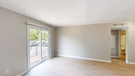Located at 4009 Hunters Glen Dr in Plainsboro, NJ, this one-bedroom, one-bathroom residence offers a well-organized single-floor layout designed for comfortable everyday living. Throughout the space, light wood-style flooring and soft neutral-toned walls create a clean, cohesive aesthetic.

The living room is a bright, open area highlighted by large sliding glass doors that lead to a private balcony, allowing natural light to fill the room and offering pleasant views of surrounding greenery. The simple, uncluttered design provides flexibility for a variety of furniture arrangements.

The kitchen features a galley-style layout with white shaker cabinetry, dark granite countertops, a subway tile backsplash, a matte black undermount sink, and stainless steel appliances including a refrigerator and range. A skylight adds additional brightness to the cooking area.

The bedroom is a well-sized, quiet retreat with the same warm flooring and neutral walls, complemented by a sliding-door closet that offers practical built-in storage. Natural light from a window enhances the room's airy feel.

The bathroom is neatly appointed with a white vanity, a full tub-shower combination with a curved curtain rod, and light, clean finishes throughout. The consistent use of light tones across all rooms gives this residence a fresh, move-in-ready character.