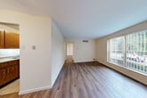 Located at 10874 Pear Blossom Ct in Saint Ann, MO, this one-bedroom, one-bathroom unit offers a well-organized, single-floor layout designed for comfortable everyday living. The living room is the heart of the space, featuring rich hardwood-style laminate flooring, neutral cream-toned walls, and large windows fitted with vertical blinds that invite generous natural light and views of the surrounding greenery. A ceiling fan adds both style and function to the area. The front entry opens directly into this bright, open living space, creating a welcoming first impression. The kitchen is efficiently laid out with warm wood cabinetry, light countertops, a double-basin sink, and black appliances including a range and refrigerator. Tile flooring grounds the kitchen area and provides a practical contrast to the laminate found throughout the rest of the unit. The bedroom is a comfortable, well-proportioned retreat with the same hardwood-style flooring, neutral walls, and a large window overlooking outdoor greenery, offering a peaceful atmosphere. A dedicated closet provides convenient storage. The bathroom is clean and straightforward, featuring a tub-shower combination with tiled surround, a toilet, and a vanity with storage.