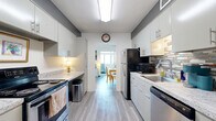 Located along the shores of Lake Erie in Lakewood, Ohio, this well-appointed 2-bedroom, 2-bathroom residence offers a thoughtfully designed single-floor layout with a seamless flow between living spaces. The entryway hallway, accented by louvered closet doors and light wood-style flooring, opens into the heart of the home. The galley-style kitchen is efficiently organized with white cabinetry, granite-look countertops, a tiled backsplash, and stainless steel appliances, leading directly into a bright dining area. The expansive living room features plush carpeting and connects to a sunroom enclosed by floor-to-ceiling sliding windows that frame sweeping, unobstructed views of Lake Erie — a true standout feature of the residence. The primary bedroom is generously sized, with soft carpeting, built-in louvered closets, and an en-suite bathroom. The second bedroom also offers comfortable proportions, carpeted floors, a ceiling fan, and ample natural light. Both bathrooms are cleanly finished with updated vanities and wood-style flooring. Throughout the residence, a neutral color palette and consistent flooring create a cohesive, modern aesthetic, while the ever-present lake backdrop lends the space a tranquil, resort-like ambiance.