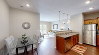 Located in Cottleville, Missouri, this well-appointed two-bedroom, two-bathroom residence offers a thoughtfully designed single-floor layout. The open-concept living, dining, and kitchen area creates a seamless flow ideal for both everyday living and entertaining. The kitchen is equipped with stainless steel appliances—including a refrigerator, range, and dishwasher—complemented by warm wood cabinetry, granite-look countertops, and stylish pendant lighting over the peninsula. Hardwood-style flooring runs throughout the main living areas, adding warmth and continuity. The living room is bright and inviting, anchored by French doors that let in natural light and offer views of the surrounding greenery. The dining area provides a cozy nook for meals. The primary bedroom is a comfortable retreat with ample space for furnishings, while the second bedroom features a large window and ceiling fan. Both bathrooms are clean and functional, with the full bath offering a tub/shower combo and wood-tone vanity cabinetry. Neutral wall tones throughout create a calm, versatile backdrop. A dedicated closet adds practical storage, rounding out this well-balanced residence in the heart of Cottleville.