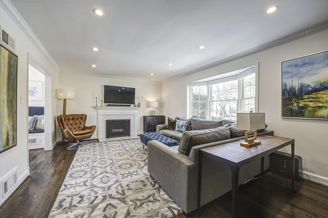 Great Room: automated bay window blinds; wood burning fireplace; wall mounted tv with Sonos. - 3227 45th St NW