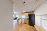 Located at 536 S University Ave in Ann Arbor, MI, this 2-bedroom, 1-bathroom unit offers a practical and well-organized layout across a single floor. The combined living and dining area is bright and functional, featuring light wood-style flooring, a drop ceiling with track lighting, a wall-mounted air conditioning unit, and a window that frames views of the surrounding Ann Arbor cityscape.

The kitchen is efficiently designed with light wood cabinetry, a white range, a black refrigerator, and a dark countertop. A peninsula with bar seating connects the kitchen to the living/dining space, creating an open, accessible flow between the two areas.

Both bedrooms feature the same warm wood-style flooring and windows offering elevated views of the city. The primary bedroom includes a mirrored sliding closet, providing practical storage. The second bedroom also benefits from natural light and includes a dedicated closet. In total, three closets are distributed throughout the unit.

The bathroom is well-appointed with a dual-sink vanity featuring granite-style countertops, warm wood cabinetry, a large mirror with overhead lighting, and a glass-enclosed shower stall.

The unit's clean, neutral palette and consistent flooring create a cohesive, functional living environment well-suited to the South University Avenue corridor.