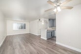 Located at 7250 Hazeltine Ave, this single-story home offers a practical and well-organized layout across three bedrooms and two bathrooms. The interior is unified by light wood-style flooring throughout, complemented by warm beige walls and clean white trim that create a bright, cohesive aesthetic.

The combined kitchen and living area serves as the heart of the home. The kitchen features gray cabinetry, light countertops, and white appliances including a gas range and full-size refrigerator. The open living area provides a welcoming, functional space with natural light filtering through slatted window blinds.

Each of the three bedrooms maintains a consistent design, with light flooring, neutral walls, and windows dressed with horizontal blinds that allow views of greenery outside. The primary bedroom offers a comfortable footprint suited for standard furnishings.

The two bathrooms are finished in a clean, modern style. One features a tub-shower combination with white tile surround, a white vanity with black hardware, and wood-style flooring. The second bathroom includes a white vanity with chrome fixtures, a window for natural light, and a mirrored medicine cabinet above the sink.

Overall, the home presents a clean, move-in ready interior with consistent finishes and practical room configurations throughout.