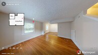 Located at 704 Louise Cir in Durham, NC, this two-story, 2-bedroom, 1-bathroom home offers a practical and well-laid-out floor plan across two evenly divided levels. The main floor features a bright, open living area with warm hardwood flooring, a textured ceiling, and large windows that invite abundant natural light and views of the surrounding greenery. A staircase with clean white paneling connects the levels seamlessly. The galley-style kitchen is well-appointed with white shaker cabinetry, granite-look countertops, a stainless steel sink, and a full-size refrigerator, with a window at the end framing a lush outdoor view. Upstairs, both bedrooms continue the hardwood flooring theme and feature textured ceilings and generous windows — the primary bedroom includes a built-in closet with shelving, while the second bedroom benefits from dual windows on a corner wall, filling the space with natural light. The full bathroom is clean and bright, outfitted with a white vanity, a mirror, and a window with greenery views. Two closets provide ample storage throughout the home. Neutral wall tones and consistent hardwood floors create a cohesive, inviting atmosphere across the entire space.