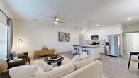 This well-appointed 2-bedroom, 2-bathroom residence is designed with a thoughtful open-concept layout that maximizes functionality and flow. The combined kitchen and living area serves as the heart of the home, featuring light wood-tone flooring throughout. The modern kitchen is outfitted with crisp white shaker cabinetry, a white subway tile backsplash, granite countertops, and a full suite of stainless steel appliances. A central island with seating provides both additional prep space and a casual dining option, accented by stylish pendant lighting overhead. The living room is bright and airy, benefiting from large windows that invite natural light, and includes a ceiling fan for added comfort. A dedicated dining area completes the open living space. Both bedrooms are carpeted for warmth and comfort. The primary bedroom is generously sized, offering a ceiling fan, a large window with outdoor views, and closet access. The second bedroom is equally comfortable with ample space. Each bathroom features white cabinetry, granite vanity tops, subway tile tub surrounds, and wood-look flooring, maintaining a clean and cohesive aesthetic throughout. A dedicated closet adds convenient storage to round out this practical and modern residence.