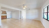 Located at 8570 W Mayo Dr in Crystal River, Florida, this single-story, 2-bedroom, 1-bathroom home offers a straightforward and functional layout. Light beige tile flooring runs throughout the entire home, providing a cohesive and easy-to-maintain surface. The living room is an open, airy space featuring a ceiling fan with light fixture and a textured ceiling, with a decorative column partially dividing it from the adjacent dining area. Natural light filters in through multiple windows, enhancing the bright, neutral interior.

The kitchen and dining area share an open space, with the kitchen equipped with warm wood-toned cabinetry, light countertops, a black electric range, an overhead vent hood, and a double sink. Ample upper and lower cabinet storage is available throughout.

Both bedrooms are well-lit, with multiple windows offering views of the surrounding greenery. Each room includes a ceiling fan and closet access, with a total of three closets distributed throughout the home. The primary bedroom is a comfortable size with natural light and direct hallway access.

The bathroom features a full tub/shower combo with white tile surround, a window for ventilation, and clean, simple fixtures. A hallway connects the main living areas to the bedrooms and bathroom, completing this efficiently designed Florida home.