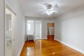 Located at 1511 Franklin Street Northeast in Washington, DC, this unit offers an efficient and well-organized single-floor layout comprising a living room, kitchen, bathroom, closet, and an additional unclassified room. Warm-toned hardwood floors run throughout the main living areas, lending a classic and inviting character to the space. The living room is an open, light-filled area featuring a ceiling fan and a charming French door with glass panels, adding architectural interest and allowing natural light to flow between spaces. A separate room with hardwood floors and a closet nook provides flexible use as a bedroom or home office. The kitchen is outfitted with warm wood cabinetry in a classic style, granite-look countertops, a stainless steel sink, a white gas range, and a full-size refrigerator — offering all the essentials in a compact yet functional footprint. The bathroom is finished in a clean, all-white palette with classic penny tile flooring, a full soaking tub with shower, a pedestal-style vanity, and a natural light source from a window with blinds. Neutral wall tones and white trim throughout the unit create a cohesive, clean aesthetic. This Washington, DC residence combines timeless details with practical amenities.