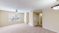 This single-floor, 2-bedroom, 2-bathroom residence offers a thoughtfully organized layout designed for comfortable everyday living. The open living room serves as the heart of the home, featuring warm neutral-toned walls, plush wall-to-wall carpeting, a ceiling fan with light fixture, and a large window that draws in natural light and frames views of lush outdoor greenery. A private exterior door provides convenient direct access from the living area.

The kitchen is outfitted with warm wood cabinetry, granite-style countertops, hardwood flooring, and stainless steel appliances including a refrigerator, range, and dishwasher — offering both style and practicality.

The spacious primary bedroom features carpet flooring, neutral walls, a ceiling fan, and a window for natural light. The second bedroom, also carpeted, provides a versatile space suitable for guests or a home office.

Both bathrooms are finished with wood-toned vanity cabinetry and granite-style countertops. The primary bathroom features a double-sink vanity, a large mirror, and a walk-in shower, while the second bathroom includes a single-sink vanity and a shower-tub combo with a decorative curtain. Both baths feature hardwood-style flooring. Additional storage is provided by a dedicated closet, and two hallways connect the rooms efficiently throughout the home.