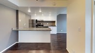 This two-floor residence offers a well-designed layout that balances functionality and comfort throughout. The main living area features rich, dark hardwood-style flooring and a striking freestanding fireplace that serves as a focal point of the room. Large sliding glass doors fill the space with natural light and provide views of the outdoor surroundings, while textured ceilings and a decorative beam with accent lighting add architectural character.

The kitchen is thoughtfully appointed with crisp white cabinetry, dark granite countertops, and a full suite of stainless steel appliances, including a refrigerator, range, and dishwasher. A peninsula counter extends the workspace and creates a natural transition into the adjoining living and dining areas, which continue the hardwood-style flooring for a cohesive look.

The bedrooms are carpeted for warmth and comfort, each featuring large windows with vertical blinds that invite generous amounts of natural light. The bathrooms echo the kitchen's refined aesthetic with matching granite vanity tops, white cabinetry, and clean, modern fixtures. One bathroom includes a tiled shower-tub combination. Throughout the residence, a neutral color palette and consistent finishes create a calm, inviting atmosphere well-suited for everyday living.