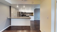 This two-floor residence offers a well-designed layout that balances functionality and comfort throughout. The main living area features rich, dark hardwood-style flooring and a striking freestanding fireplace that serves as a focal point of the room. Large sliding glass doors fill the space with natural light and provide views of the outdoor surroundings, while textured ceilings and a decorative beam with accent lighting add architectural character.

The kitchen is thoughtfully appointed with crisp white cabinetry, dark granite countertops, and a full suite of stainless steel appliances, including a refrigerator, range, and dishwasher. A peninsula counter extends the workspace and creates a natural transition into the adjoining living and dining areas, which continue the hardwood-style flooring for a cohesive look.

The bedrooms are carpeted for warmth and comfort, each featuring large windows with vertical blinds that invite generous amounts of natural light. The bathrooms echo the kitchen's refined aesthetic with matching granite vanity tops, white cabinetry, and clean, modern fixtures. One bathroom includes a tiled shower-tub combination. Throughout the residence, a neutral color palette and consistent finishes create a calm, inviting atmosphere well-suited for everyday living.