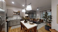 Located in Rogers, Arkansas, this single-floor residence blends modern design with warm, inviting details across a well-planned open-concept layout. The kitchen is a standout feature, outfitted with grey shaker-style cabinetry, stainless steel appliances including a French door refrigerator and electric range, stone-look countertops, a white subway tile backsplash, open wood shelving, and a central island that doubles as a dining and prep space. Pendant lighting with globe shades adds an industrial-chic touch overhead.

The kitchen flows seamlessly into the living area, where a distinctive black grid-panel partition serves as an architectural divider without closing off the space. The living room features warm wood-look flooring, natural light from windows dressed with patterned curtains, a built-in media wall, and a cozy seating arrangement suited for everyday living.

The bedroom is anchored by a sleek black four-poster bed frame, complemented by plush carpeting, wall art, and ample dresser storage. The bathroom offers a grey vanity with stone countertop, a large mirror with modern lighting, tiled walls, built-in shelving, and a tub-shower combination with hardwood-style flooring completing the space with functional elegance.