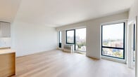 Located at 166 Van Reipen Ave in Jersey City, NJ, this thoughtfully designed unit offers five bedrooms, two bathrooms, and a combined kitchen and living area across a single floor. Light-toned hardwood flooring flows consistently throughout, lending a clean and cohesive aesthetic to every room. The open-concept living area is bathed in natural light through large black-framed floor-to-ceiling windows that frame sweeping views of the Jersey City skyline and surrounding neighborhood. The modern kitchen is a standout feature, equipped with stainless steel appliances, a large center island with a white quartz countertop, a deep undermount sink, and a combination of light wood and gray cabinetry that reaches the ceiling for ample storage. The five bedrooms are bright and well-proportioned, several benefiting from large windows with elevated city views. The two bathrooms are finished in a contemporary style — one features a wall-mounted toilet and glass-enclosed walk-in shower with tile surround, while the second includes a floating dark vanity with a lit mirror and tiled flooring. Three closets provide generous storage throughout the unit. The overall ambiance is clean, modern, and light-filled, making this a highly functional and stylish urban residence.