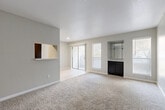 This single-story, one-bedroom, one-bathroom home in Garland, Texas offers a thoughtfully designed layout that maximizes every square foot. The open-concept living and kitchen area serves as the heart of the home, where plush carpeting flows through the living space while clean tile flooring defines the kitchen zone. A pass-through window connects the kitchen to the living area, adding a sense of openness and functionality. The kitchen features dark cabinetry, a full-size refrigerator, and a range, all lined along a galley-style corridor with tile flooring and ample overhead lighting. The living room is bathed in natural light from large windows and a sliding glass door that opens to the outdoors. A built-in shelving nook with dark cabinetry and a marble-style countertop adds a distinctive design touch to the living space. The bedroom is a comfortable retreat with soft carpet, a ceiling fan with light fixture, a large window for natural light, and a generously sized sliding-door closet. An additional closet provides further storage convenience. The bathroom features tile flooring, a vanity with a marble-style countertop, dark cabinetry, and a mirrored medicine cabinet. Neutral tones and textured ceilings throughout give the home a clean, cohesive aesthetic.