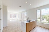 Located at 5300 Wisconsin Ave in Washington, DC's Chevy Chase neighborhood, this thoughtfully designed 3-bedroom, 2-bathroom residence offers a clean, modern aesthetic across a single floor. The open-concept living area seamlessly connects the dining room, kitchen, and living room, all unified by light-toned hardwood flooring and crisp white walls that maximize brightness. Large windows throughout flood the space with natural light and frame views of the surrounding neighborhood's greenery and streetscape.

The kitchen serves as the heart of the home, anchored by a striking island with a marble-look countertop, an undermount sink, and warm wood cabinetry. Stainless steel appliances, including a French door refrigerator, electric range, and built-in microwave, complete the contemporary culinary space.

The spacious primary bedroom features a generous footprint with abundant closet storage. The en-suite primary bathroom is well-appointed with a double-sink vanity, warm wood cabinetry, white quartz countertops, and a glass-enclosed walk-in shower. A second full bathroom includes a soaking tub with tiled surround. The two additional bedrooms are bright and well-proportioned. The residence also includes a dedicated laundry room and five closets, offering exceptional storage throughout.