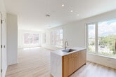 Located at 5300 Wisconsin Ave in Washington, DC's Chevy Chase neighborhood, this thoughtfully designed 3-bedroom, 2-bathroom residence offers a clean, modern aesthetic across a single floor. The open-concept living area seamlessly connects the dining room, kitchen, and living room, all unified by light-toned hardwood flooring and crisp white walls that maximize brightness. Large windows throughout flood the space with natural light and frame views of the surrounding neighborhood's greenery and streetscape.

The kitchen serves as the heart of the home, anchored by a striking island with a marble-look countertop, an undermount sink, and warm wood cabinetry. Stainless steel appliances, including a French door refrigerator, electric range, and built-in microwave, complete the contemporary culinary space.

The spacious primary bedroom features a generous footprint with abundant closet storage. The en-suite primary bathroom is well-appointed with a double-sink vanity, warm wood cabinetry, white quartz countertops, and a glass-enclosed walk-in shower. A second full bathroom includes a soaking tub with tiled surround. The two additional bedrooms are bright and well-proportioned. The residence also includes a dedicated laundry room and five closets, offering exceptional storage throughout.