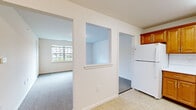 Located at 8 Isabel Lane, Unit 110 in Monticello, NY, this one-bedroom, one-bathroom unit offers a well-organized, single-floor layout designed for comfortable everyday living. The kitchen is a functional highlight, featuring warm honey-toned wood cabinetry with brass hardware, white countertops, a white tile backsplash, and white appliances including a refrigerator and electric range. Light tile flooring completes the kitchen's clean, practical aesthetic. The living room is bright and inviting, with large windows that welcome natural light and views of the surrounding greenery. Soft wall-to-wall carpeting extends through the living areas and into the spacious bedroom, which offers generous square footage, large windows, and a pass-through closet providing additional storage access. A dedicated walk-in closet features built-in wire shelving systems, maximizing storage capacity. The bathroom is finished with light tile flooring and includes a glass-door shower stall and accessibility-friendly grab bars. Throughout the unit, neutral white walls and clean lines create a consistent, move-in-ready atmosphere. The layout flows efficiently between rooms, making the most of the available space while maintaining a comfortable and functional living environment.