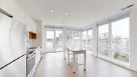 Located in Alexandria, Virginia, this contemporary 2-bedroom, 2-bathroom residence offers a bright, modern living experience with thoughtful design throughout. The open-concept kitchen and living area serves as the heart of the home, featuring light hardwood flooring, recessed lighting, and white cabinetry paired with stainless steel appliances. Floor-to-ceiling windows wrap around the living space, flooding it with natural light and framing expansive views of the Alexandria cityscape. A private balcony extends the living area outdoors, ideal for enjoying the surrounding urban scenery.

A clean, well-lit hallway connects the main living area to the private quarters, lined with multiple closets offering generous storage. Both bedrooms are carpeted and feature ceiling fans, large windows with city views, and ample closet space. The primary bathroom is finished with a dual-sink vanity, wood-tone flooring, and a glass-enclosed walk-in shower with large-format tile. The second bathroom features a full soaking tub with tiled surround. Throughout the residence, a neutral color palette, black hardware accents, and consistent modern finishes create a cohesive and refined aesthetic well-suited to both comfortable living and professional settings.