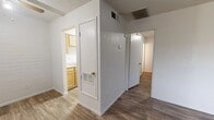 This 2-bedroom, 1-bathroom unit is thoughtfully laid out across a single floor, making efficient use of its compact footprint. Wood-look flooring runs consistently throughout the space, lending a cohesive and clean aesthetic to every room.

The living area welcomes you at the entrance, featuring a ceiling fan, painted brick accent walls, and a front-facing window dressed with vertical blinds that allow natural light to filter in. The kitchen is positioned just off the main living space and includes light wood cabinetry, a double-basin stainless steel sink, laminate countertops, and a white refrigerator — all set against a painted brick backsplash.

The primary bedroom is generously sized and includes an open closet with a double rod, providing ample storage. The second bedroom also features painted brick walls, a window with vertical blinds, and a built-in closet with a hanging rod. Both bedrooms benefit from textured ceilings and the same durable flooring found throughout the unit.

The bathroom is clean and functional, featuring a full tub and shower combo with a built-in shelf niche, a wood-framed vanity, and a window above the shower that brings in additional natural light. Ceiling HVAC vents are present throughout, ensuring consistent climate control across the unit.