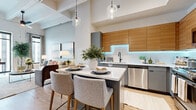 Located in the heart of downtown Houston, this thoughtfully designed one-bedroom, one-bathroom residence blends contemporary style with industrial-chic character. Soaring ceilings with exposed beams and large floor-to-ceiling windows flood the open-concept living, dining, and kitchen area with natural light and sweeping urban views. Light hardwood flooring flows throughout, anchoring the bright, airy ambiance.

The chef's kitchen is a standout feature, boasting warm wood upper cabinetry, sleek gray lower cabinets, LED under-cabinet lighting, white quartz countertops, stainless steel appliances, and a generous island with bar seating — perfect for both cooking and casual dining.

The living area offers generous proportions, complemented by exposed white structural beams and a ceiling fan, creating a loft-inspired atmosphere. The bedroom is a serene retreat with plush carpet, tall windows with city views, exposed ductwork adding an industrial touch, and a sliding barn door leading to a dedicated walk-in closet.

The spa-inspired bathroom features a double-sink vanity with gray cabinetry, illuminated LED mirrors, light wood-tone flooring, and a walk-in shower with frameless glass doors, delivering a polished and functional finish throughout.