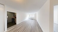 This 490 square foot apartment, located at 401 E 34th St in New York City, offers a thoughtfully designed living space. The single-floor layout comprises one bedroom, one bathroom, a kitchen, and a living room. The primary bedroom, measuring 140 square feet, provides a cozy retreat.

The apartment boasts modern finishes throughout, with light-colored wood-look flooring creating a sense of warmth and continuity. Large windows in both the living area and bedroom flood the space with natural light and offer engaging city views, enhancing the sense of openness.

The bathroom features a clean, contemporary design with large beige tiles, a standard bathtub-shower combination, and a modern vanity with a granite countertop. Storage is maximized with a mirrored medicine cabinet.

The kitchen, while compact, is efficiently designed with stainless steel appliances, including a gas range and over-the-range microwave. Dark wood cabinetry contrasts nicely with the light countertops and backsplash.

The living area is open and versatile, allowing for flexible furniture arrangements. Built-in closets with sleek white doors provide ample storage space. The overall aesthetic is clean and minimalist, with neutral tones creating a calm and inviting atmosphere perfect for modern urban living.