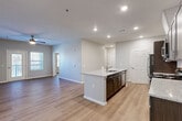 Located at 2747 Kelly Lake Rd in Decatur, GA, this well-designed 2-bedroom, 2-bathroom residence offers a thoughtful single-floor layout with modern finishes throughout. The open-concept living area seamlessly connects the kitchen, dining, and living spaces, creating a bright and functional environment illuminated by recessed lighting. The kitchen is a standout feature, showcasing granite countertops, a center island with a built-in sink, dark espresso cabinetry, and a full suite of stainless steel appliances including a refrigerator, range, and microwave. Wood-look luxury vinyl plank flooring runs throughout the entire home, adding warmth and cohesion. Both bedrooms are well-proportioned, each equipped with a ceiling fan and natural light from windows with views of the outdoors. The primary bedroom offers a comfortable footprint with closet access. Both bathrooms mirror the home's design aesthetic, featuring granite-topped vanities with dark cabinetry and tub-shower combinations. Additional conveniences include a dedicated laundry area, utility room, and multiple closets for ample storage. The entrance provides a welcoming transition into this clean, contemporary home.