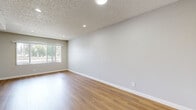 Located at 601 E 8th St in Azusa, California, this one-bedroom, one-bathroom residence offers a thoughtfully organized single-level layout that makes efficient use of its space. Warm wood-look laminate flooring flows consistently throughout the unit, complemented by neutral gray walls and crisp white baseboards that create a clean, cohesive aesthetic.

The living area is bright and open, featuring a large window fitted with vertical blinds that allow generous natural light to filter in while offering privacy. Recessed lighting adds a polished touch to the ceiling, which carries a classic textured finish throughout the unit.

The bedroom is a comfortable, well-proportioned space with two windows that provide cross-ventilation and views of the surrounding greenery. A sliding-door closet offers practical built-in storage, and the same warm flooring and neutral tones continue seamlessly from the main living areas.

The kitchen is neatly integrated into the floor plan, visible from the main living space and outfitted with standard appliances and cabinetry. The bathroom features a full-size soaking tub and shower combination with clean white surrounds and chrome fixtures, maintaining the unit's consistent, functional design.

Overall, this residence presents a bright, move-in-ready atmosphere with a simple, understated style suited to comfortable everyday living in the heart of Azusa.