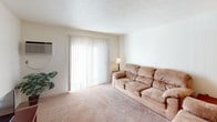 Located at 245 Memorial Dr in Sturgis, Michigan, this single-floor unit offers a practical and well-organized layout suited for comfortable everyday living. The kitchen is designed for efficiency, featuring white cabinetry with warm wood trim, a stainless steel sink, a full-size refrigerator, a dishwasher, and ample counter space — all finished with easy-to-maintain tile flooring. Adjacent to the kitchen, the dining area provides a dedicated space for meals, complete with carpeted flooring and access to closet storage nearby. The living room is generously proportioned, offering soft carpeting, a large sliding glass door that fills the space with natural light, and a wall-mounted air conditioning unit for climate control. Multiple bedrooms are featured throughout the unit, each carpeted and equipped with windows that allow in natural light and views of the surrounding greenery. The bedrooms offer functional layouts with room for standard furnishings, including desks, dressers, and seating. The bathroom is cleanly appointed with tile flooring, a shower-tub combination, and a baseboard heater. Throughout the unit, neutral tones and practical finishes create a clean, understated ambiance well-suited for residential living.