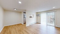 Located at 46 Camp St in Middletown, CT, this one-bedroom, one-bathroom unit offers a well-organized layout across a single floor. Light-toned hardwood flooring runs consistently throughout the space, contributing to a clean, cohesive aesthetic.

The combined kitchen and living area forms the heart of the unit. The kitchen is equipped with stainless steel appliances, including a refrigerator and range, complemented by white cabinetry, granite-style countertops, and a window that brings in natural light. A pass-through opening connects the kitchen to the living area, enhancing the open feel. The living room features recessed lighting, a wall-mounted air conditioning unit, baseboard heating, and a sliding glass door dressed with vertical blinds, providing outdoor access and additional natural light.

The bedroom is a generously sized private retreat with recessed lighting, a window with blinds, and baseboard heating. The bathroom is finished in white tile, featuring a tub-shower combination with a window above, a white vanity, and a mirror.

A hallway connects the main living areas, completing the efficient and functional floor plan.