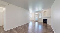 Located at 1300 S Willow St in Denver, Colorado, this three-bedroom, two-bathroom single-floor home offers a well-organized and functional layout. The open living room is a standout space, featuring rich hardwood-style flooring, a textured ceiling, a fireplace with a clean white mantle, and an elegant arched wall niche. Natural light flows in through multiple windows and a glass-paneled front door, creating a bright and welcoming atmosphere. Adjacent to the living area, the kitchen is equipped with white shaker-style cabinetry, granite-look countertops, a subway tile backsplash, stainless steel appliances including a refrigerator, range, and microwave, and warm wood-tone flooring with track lighting overhead. The three bedrooms are finished with plush carpeting and crisp white walls. The spacious primary bedroom includes a walk-in closet outfitted with multiple hanging rods and shelving. Additional bedrooms are well-sized with natural light from windows. The two bathrooms include a tub-shower combo with white tile surround. A dedicated in-unit laundry area houses a full-size washer and dryer. Two closets provide ample storage throughout the home, rounding out this clean and move-in-ready residence.
