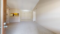 Located in Denver, CO, this one-bedroom, one-bathroom residence offers a thoughtfully arranged single-floor layout. The living room serves as the heart of the home, featuring striking vaulted ceilings that lend an open, airy feel and a tile-surround fireplace with a white mantel as a focal point. Natural light filters in through multiple windows and a glass door that leads out to the private balcony. Built-in shelving adds both functionality and character to the living area. The dining room flows naturally from the living space, creating a seamless entertaining area. The galley-style kitchen is outfitted with warm wood cabinetry, hardwood-style flooring, a breakfast bar pass-through, and black appliances, along with a dedicated pantry closet. The spacious bedroom features plush carpet, a ceiling fan, a natural window view, and convenient access to the full bathroom. The bathroom includes a full tub-shower combination with clean white tile surround. Additional highlights include a welcoming entrance, two closets for generous storage, a utility room, and an in-unit laundry area. Neutral tones and carpet throughout the main living and sleeping areas create a warm, cohesive ambiance.