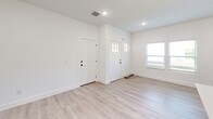 Located at 1202 Chelsey Ln in Inman, SC, this two-story home offers a thoughtfully designed layout spread across two well-proportioned floors. The interior is finished in a clean, contemporary style, featuring light-toned luxury vinyl plank flooring and crisp white walls throughout, creating a bright and cohesive aesthetic.

The kitchen is a standout feature, showcasing white shaker-style cabinetry extending to the ceiling, white quartz countertops, a subway tile backsplash with matte black fixtures, and a full suite of stainless steel appliances including a refrigerator, range, microwave, and dishwasher. A kitchen island with a wood-panel accent base provides additional prep and seating space, illuminated by pendant lighting overhead.

The main floor also includes an open living area, a welcoming entryway with craftsman-style doors and natural light from surrounding windows, a dedicated laundry room with shelving and hookups, and an attached garage with an automatic opener. Three bedrooms are distributed across both floors, including a spacious primary suite, each featuring recessed lighting and closet access. The three bathrooms are finished with white vanities, matte black hardware, and tub-shower combinations. A staircase with a clean balustrade connects both levels, completing this move-in-ready home.