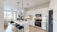 This thoughtfully designed single-floor residence in Raleigh, NC offers a cohesive open-concept layout that maximizes every square foot. The kitchen is a standout feature, showcasing crisp white shaker cabinetry, quartz countertops, a classic subway tile backsplash, stainless steel GE appliances, and a central island with seating — all illuminated by elegant pendant lighting. It flows seamlessly into the living room, where light wood-style flooring, a ceiling fan, large windows, and a glass door invite abundant natural light and provide access to an outdoor balcony. The bedroom is a serene retreat, featuring plush carpet, a generous window with exterior views, and convenient access to the closet, which offers multi-tier shelving and hanging rods for organized storage. The bathroom is well-appointed with dual sinks, white cabinetry, quartz countertops, wood-look flooring, and a tub/shower combination clad in marble-style tile. A dedicated laundry room houses a full-size side-by-side GE washer and dryer. Neutral warm-gray tones and consistent finishes throughout lend the space a modern, cohesive aesthetic.