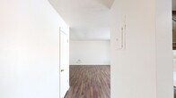 Summit West Two Bedroom B1 (Unit 42C) is a single-floor residence thoughtfully designed for comfortable everyday living. Dark hardwood-style flooring flows throughout the main living areas and bedrooms, providing a warm and cohesive aesthetic against the crisp white walls and textured ceilings.

The living room is generously sized and filled with natural light, courtesy of large sliding glass doors that open to a private patio. A ceiling fan adds comfort, while a built-in wall niche provides a functional accent detail.

The kitchen features rich, dark wood cabinetry extending to the upper walls, light countertops, and a full suite of stainless steel appliances including a refrigerator, dishwasher, and range. A bright panel ceiling light illuminates the workspace effectively.

Both bedrooms are well-proportioned and bright, each featuring windows that bring in natural light and hardwood-style flooring. The rooms offer ample wall space to accommodate a variety of furniture arrangements.

The two bathrooms are finished consistently, each offering a tiled shower-tub combination, a vanity with wood cabinetry and a wide mirror, and Hollywood-style lighting. One bathroom features tile flooring, while the other complements the hardwood-style found throughout the rest of the home.