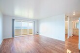Located at 365 Talbot Ave in Pacifica, CA, this well-appointed 1-bedroom, 2-bathroom single-floor residence offers a bright, open layout with stunning Pacific Ocean views. Warm hardwood flooring flows throughout, unifying each room with a clean, cohesive aesthetic.

The combined dining and living area is generously proportioned, bathed in natural light, and anchored by sliding glass doors that open to a private patio — framing sweeping ocean vistas. The galley-style kitchen is thoughtfully designed with white shaker cabinetry, quartz countertops, stainless steel appliances including a refrigerator, range, microwave, and dishwasher, plus a stainless steel sink.

The spacious primary bedroom features a mirrored sliding-door closet and a large window with direct ocean views, lending it a serene, light-filled character. Three closets total provide ample storage throughout the home. The primary bathroom offers a dual-sink vanity with quartz countertops and white cabinetry, while the second bathroom includes a full bathtub with shower. A hallway connects the spaces efficiently, completing this thoughtfully laid-out coastal residence.