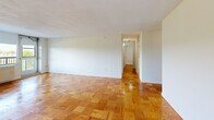Located on the ninth floor at 101 Monmouth St in Brookline, MA, this two-bedroom, two-bathroom residence offers a well-organized single-floor layout with a comfortable sense of space throughout. Distinctive parquet hardwood flooring runs through the living room, hallway, and both bedrooms, lending a classic warmth to the interior. The living room is generously sized, featuring clean white walls and an open feel that flows naturally toward the hallway and private quarters. The kitchen is equipped with white cabinetry offering ample storage, white subway tile backsplash, light tile flooring, and a full suite of appliances including a refrigerator, electric range, microwave, dishwasher, and sink. The spacious primary bedroom benefits from a window with pleasant treetop views, allowing natural light to fill the room. The second bedroom also features the same signature parquet floors and track lighting overhead. Both bathrooms are finished with classic white subway tile and mosaic tile flooring. One bathroom includes a walk-in shower with frosted glass doors, while the other offers a full tub and shower combination — both accented with black tile trim and grab bars. A dedicated closet and hallway complete the practical layout of this Brookline residence.