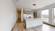 Located at 2132 Stokes Blvd in Cleveland's vibrant University Circle area, this well-appointed 2-bedroom, 2-bathroom residence offers a thoughtfully designed single-floor layout with a clean, contemporary aesthetic throughout. Light-toned luxury vinyl plank flooring runs continuously through every room, complementing the crisp white walls and creating a bright, cohesive feel.

The open-concept kitchen and living area serves as the heart of the unit. The kitchen is outfitted with sleek grey cabinetry, white quartz countertops, a subway tile backsplash, stainless steel appliances including a refrigerator, range, and built-in microwave, and a large center island with pendant lighting. Oversized windows flood the space with natural light and frame views of the surrounding Cleveland cityscape.

The primary bedroom is a generously sized retreat featuring dual large windows that bring in additional natural light and city views, along with a double-door closet offering ample storage. The second bedroom is bright and well-proportioned with its own closet access. Three total closets are distributed throughout the unit for added convenience.

Both bathrooms carry the modern design language forward, featuring grey floating vanities with white countertops, matte black fixtures, large mirrors, and wood-toned LVP flooring. The primary bath includes a glass-enclosed walk-in shower. An in-unit laundry area completes this functional and stylish residence.