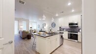 Located on Hibiscus Ave in Boulder, CO, this thoughtfully designed one-bedroom, one-bathroom residence offers an efficient and modern single-floor layout. Light wood-tone flooring flows consistently throughout, lending warmth and visual continuity across all rooms.

The open-concept kitchen is a standout feature, anchored by a large center island with dark countertops and seating for multiple guests. White shaker-style cabinetry extends to the ceiling, complemented by a textured tile backsplash and a full suite of stainless steel appliances, including a French door refrigerator, microwave, and range. Pendant lighting above the island adds a polished finishing touch.

The kitchen opens seamlessly into the living room, which is filled with natural light from large windows and a glass door leading to the private balcony. The space feels airy and welcoming, ideal for both relaxing and entertaining.

The bedroom is a calm, well-proportioned retreat featuring multiple windows with roller shades, a ceiling fan, and direct access to the bathroom. The bathroom offers a full-length vanity with dark countertops, an undermount sink, and a tub-shower combo with dark tile surround.

Additional highlights include four closets for generous storage, an in-unit laundry area, a pantry, and a hallway connecting the functional zones of the home.