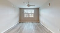 This contemporary apartment in Sarasota, FL offers 820 square feet of efficiently designed living space. The open-concept floor plan seamlessly integrates the kitchen and living areas, creating a spacious feel. The kitchen is a highlight, featuring crisp white cabinetry, granite countertops, and stainless steel appliances including a refrigerator, dishwasher, and built-in microwave.

Both bedrooms are generously sized, with the primary bedroom measuring 150 square feet. Each room is equipped with a ceiling fan and large windows that invite natural light. The apartment boasts three full bathrooms, all finished with modern fixtures and neutral tiling.

Throughout the space, warm wood-look flooring adds a touch of elegance and complements the soft, neutral wall colors. The apartment includes practical amenities such as ample closet space with wire shelving systems for organized storage.

The overall design emphasizes clean lines and a bright, airy atmosphere, making this apartment an ideal blend of comfort and contemporary style. Its location on North Tamiami Trail provides easy access to Sarasota's amenities, making it a convenient urban dwelling.