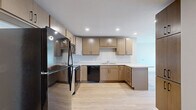 Located at 556 W Lake St in Minneapolis, MN, this single-floor residence offers three bedrooms and two bathrooms within a well-designed, modern layout. Light hardwood flooring flows consistently throughout the unit, creating a cohesive and warm aesthetic from room to room.

The kitchen serves as a functional centerpiece, featuring light wood cabinetry with sleek black hardware, white countertops with a peninsula, recessed lighting, and black appliances including a refrigerator, range, microwave, and dishwasher. The kitchen connects openly to the living area, supporting an efficient, open-concept flow.

The three bedrooms are bright and clean, with neutral walls, hardwood floors, and windows that allow natural light to enter. The primary bedroom offers a generous footprint with good proportions for a variety of furniture arrangements. The secondary bedrooms are well-sized and similarly finished.

Both bathrooms follow a consistent modern design, each featuring large-format tile flooring, a wood-toned floating vanity with black hardware, white countertops, and a tiled tub-shower combination. Recessed lighting and clean white walls give each bathroom a bright, contemporary feel. The overall ambiance of the unit is clean, modern, and move-in ready.