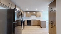 Located at 556 W Lake St in Minneapolis, MN, this single-floor residence offers three bedrooms and two bathrooms within a well-designed, modern layout. Light hardwood flooring flows consistently throughout the unit, creating a cohesive and warm aesthetic from room to room.

The kitchen serves as a functional centerpiece, featuring light wood cabinetry with sleek black hardware, white countertops with a peninsula, recessed lighting, and black appliances including a refrigerator, range, microwave, and dishwasher. The kitchen connects openly to the living area, supporting an efficient, open-concept flow.

The three bedrooms are bright and clean, with neutral walls, hardwood floors, and windows that allow natural light to enter. The primary bedroom offers a generous footprint with good proportions for a variety of furniture arrangements. The secondary bedrooms are well-sized and similarly finished.

Both bathrooms follow a consistent modern design, each featuring large-format tile flooring, a wood-toned floating vanity with black hardware, white countertops, and a tiled tub-shower combination. Recessed lighting and clean white walls give each bathroom a bright, contemporary feel. The overall ambiance of the unit is clean, modern, and move-in ready.