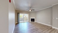 Located in Sacramento, CA, this well-appointed 2-bedroom, 3-bathroom single-floor residence offers a thoughtfully designed layout with modern finishes throughout. Light wood-style vinyl flooring runs consistently across the home, complemented by neutral gray-toned walls and crisp white trim.

The open-concept living room is a welcoming centerpiece, featuring crown molding, a ceiling fan, a white-mantled fireplace, and sliding glass doors that lead to an outdoor balcony with lush tree views. The adjacent kitchen is outfitted with white shaker cabinetry, dark countertops, stainless steel appliances including a refrigerator, microwave, range, and dishwasher, and a galley-style layout that maximizes efficiency.

The primary bedroom is a comfortable retreat with a ceiling fan and natural light from a window overlooking greenery. Its en-suite bathroom features a dual-sink vanity with white cabinetry, dark countertops, a large mirror, and a separate water closet. The second bedroom also includes a ceiling fan and window with outdoor views. Three full bathrooms ensure ample convenience for residents and guests. A dedicated laundry room with overhead cabinetry and an in-unit washer adds practical functionality to this well-rounded Sacramento home.