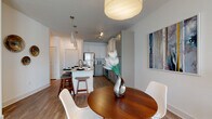 Located at 2604 Executive Dr in Venice, Florida, this single-story residence offers a thoughtfully designed open-concept layout with contemporary finishes throughout. The kitchen serves as a central highlight, featuring granite countertops, a two-tone cabinet scheme pairing white upper cabinets with soft gray-green lower cabinetry, a classic subway tile backsplash, and a full suite of stainless steel appliances including a range, microwave, and refrigerator. A peninsula with seating provides a natural transition into the dining area, where pendant lighting adds warmth and definition to the space.

The living room is bright and inviting, benefiting from multiple large windows that invite abundant natural light and views of the surrounding area. Wood-look flooring runs throughout the main living areas, lending a cohesive and clean aesthetic. The bedrooms are carpeted for comfort, each offering generous window placement and ceiling fans. The primary bedroom provides ample space and connects to a well-appointed bathroom featuring granite-topped white vanity cabinetry, wood-look flooring, and convenient closet access via a hallway. The overall ambiance is modern, airy, and move-in ready, reflecting a polished residential aesthetic suited to Florida living.
